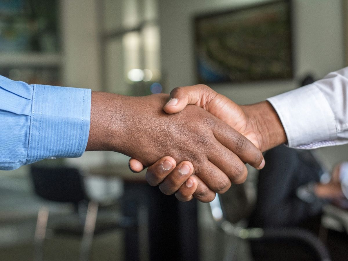 Two professionals shaking hands in an office